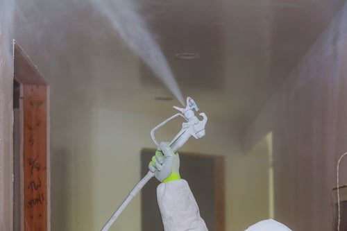 Technician sanitizing a hallway with a professional sprayer